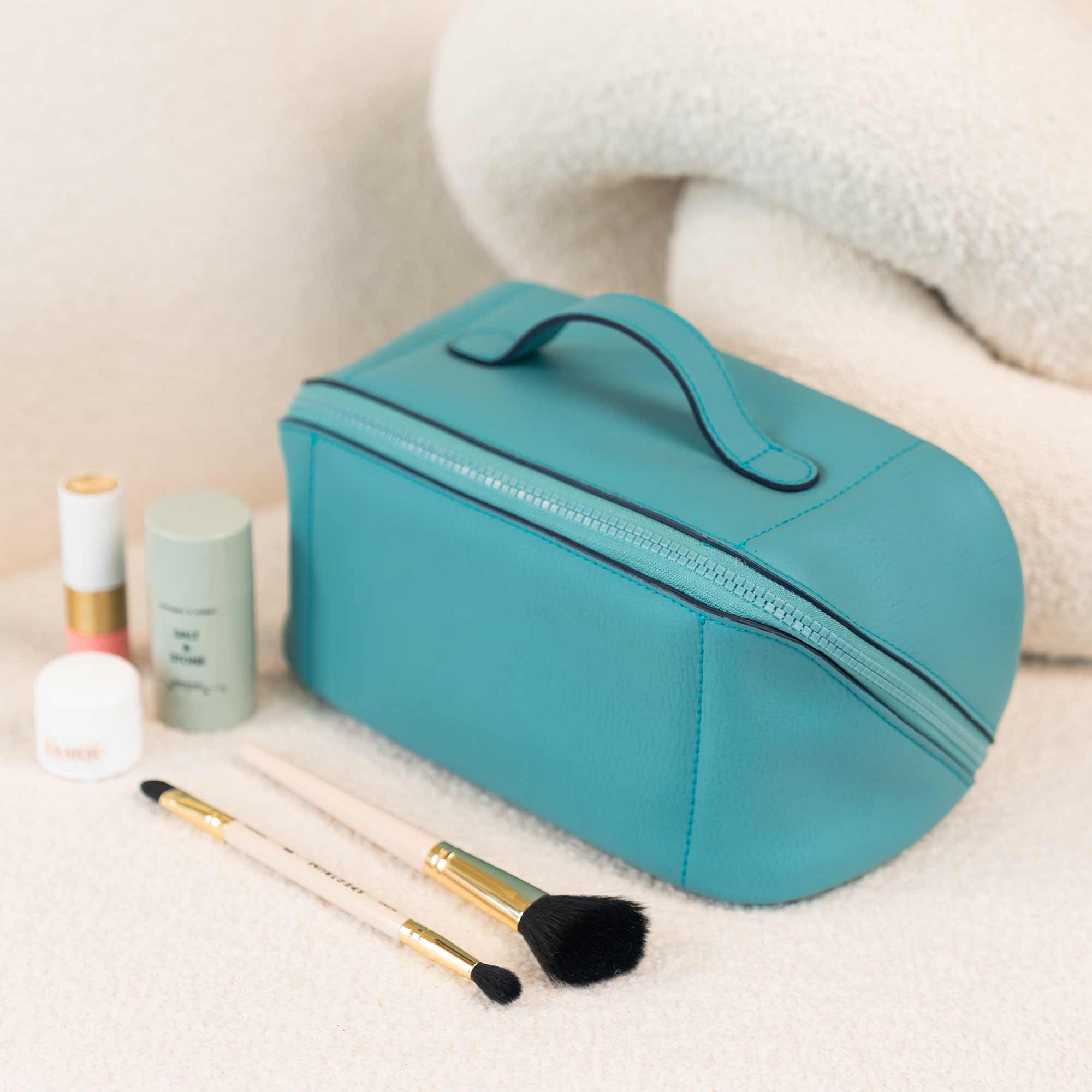 Eco-friendly turquoise vegan leather make-up bag for responsible beauty lovers.